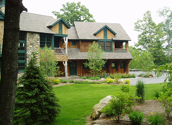 Picture of large shingle home with large trees and green plantings