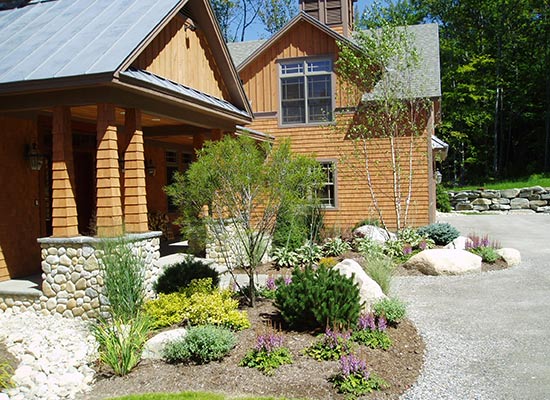 Picture of wooden sided house entrance with small trees and gardens