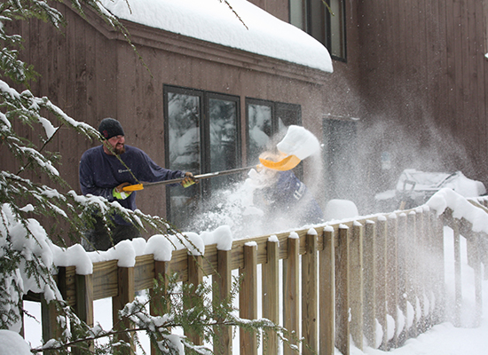 Picture of two men shoveling snow off deck